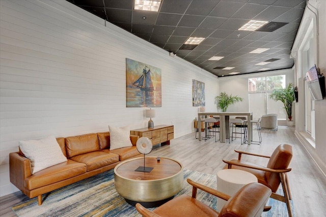 living room featuring wood-type flooring and a drop ceiling