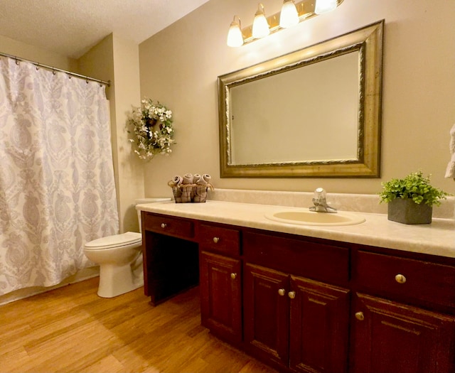 bathroom featuring hardwood / wood-style floors, vanity, a textured ceiling, and toilet