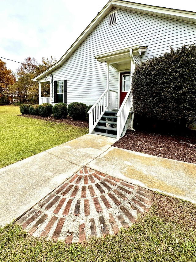 entrance to property with a lawn