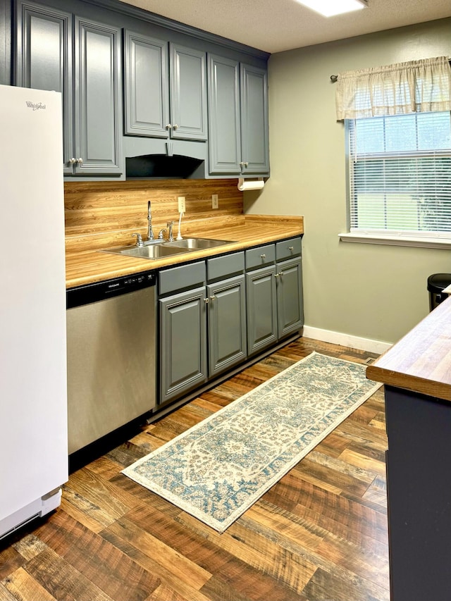 kitchen featuring wooden counters, sink, dishwasher, white fridge, and dark hardwood / wood-style floors