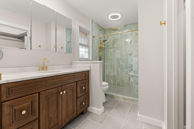 bathroom featuring vanity, tile patterned flooring, toilet, and tiled shower