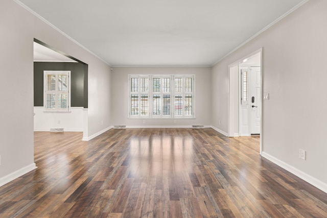 spare room featuring dark hardwood / wood-style flooring and crown molding