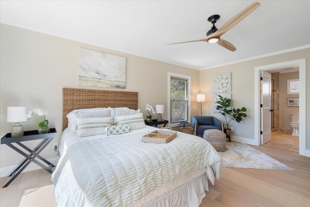 bedroom with light wood-type flooring, ornamental molding, ensuite bath, baseboards, and ceiling fan