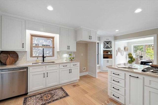 kitchen featuring visible vents, light wood-type flooring, a sink, white cabinets, and dishwasher