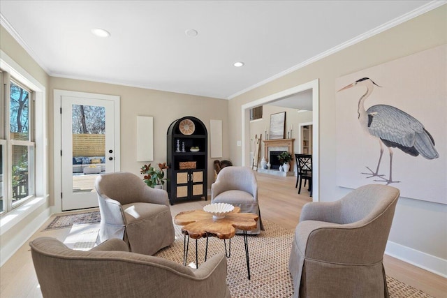 sitting room featuring recessed lighting, light wood-style flooring, baseboards, and ornamental molding