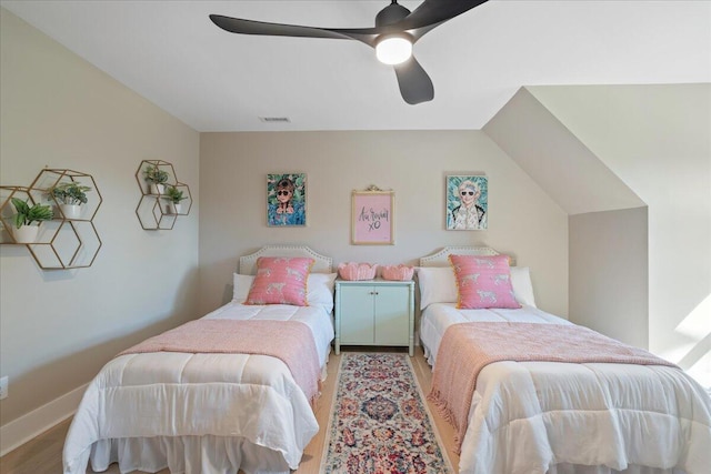 bedroom with wood finished floors, a ceiling fan, visible vents, and baseboards