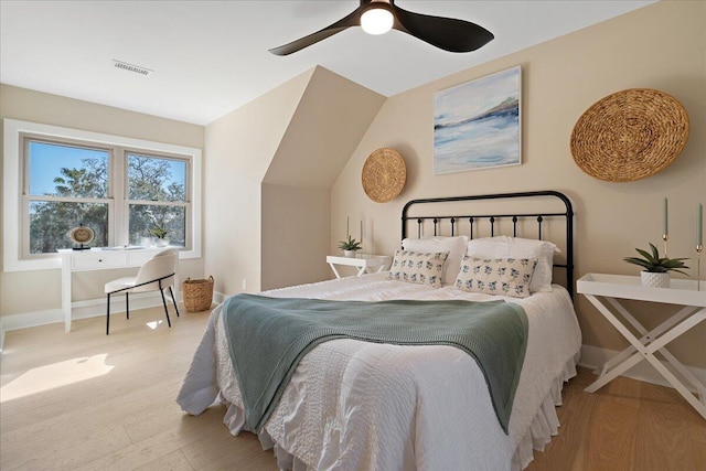 bedroom featuring visible vents, a ceiling fan, baseboards, and wood finished floors