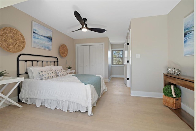 bedroom featuring ceiling fan, a closet, baseboards, and light wood-style flooring