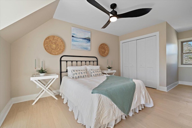 bedroom featuring baseboards, vaulted ceiling, wood finished floors, a closet, and a ceiling fan