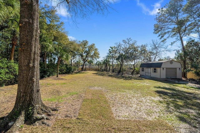 view of yard with a garage and an outbuilding