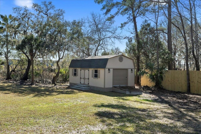 view of outbuilding featuring an outbuilding, entry steps, and fence