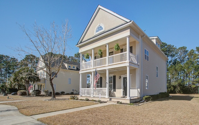 neoclassical home featuring covered porch and a balcony