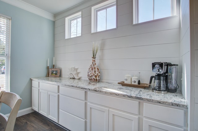 bar featuring baseboards, dark wood-style flooring, and crown molding