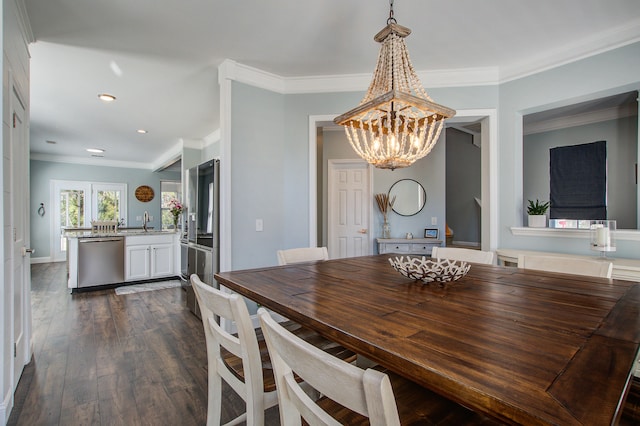 dining area with an inviting chandelier, ornamental molding, dark wood-style flooring, and recessed lighting