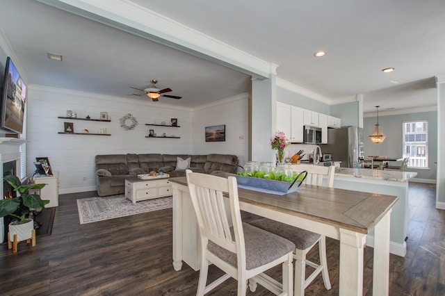 dining room featuring recessed lighting, dark wood-style flooring, a fireplace, baseboards, and crown molding