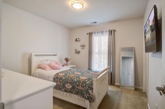 bedroom featuring baseboards, visible vents, and light colored carpet