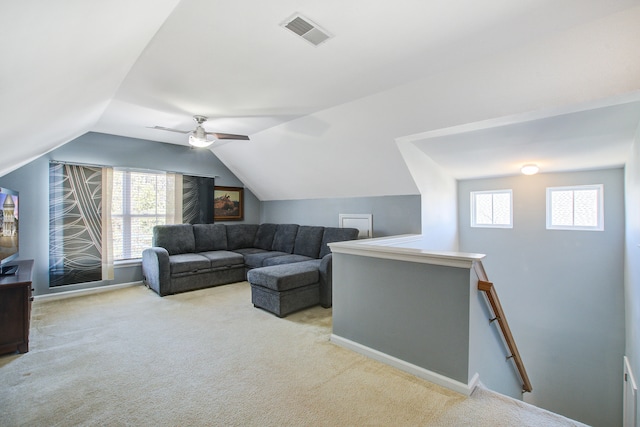 carpeted living area with lofted ceiling, a healthy amount of sunlight, visible vents, and baseboards