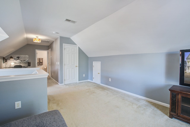 bonus room with light carpet, vaulted ceiling, visible vents, and baseboards