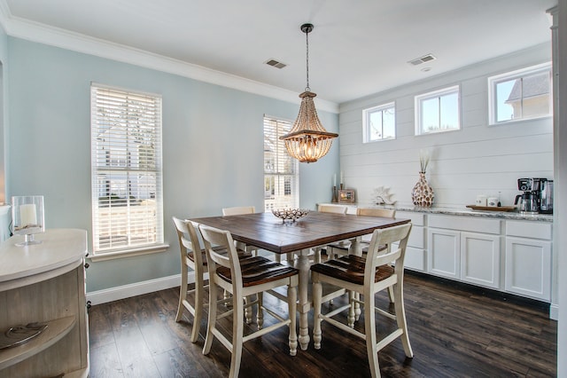 dining area featuring dark wood-style floors, baseboards, visible vents, and crown molding