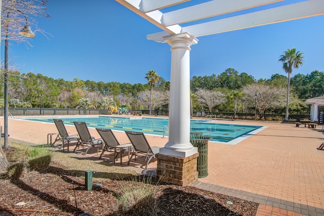 pool with a patio area and fence