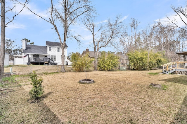 view of yard featuring a wooden deck and fence