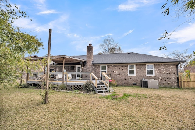 rear view of property featuring brick siding, central air condition unit, a yard, a deck, and crawl space