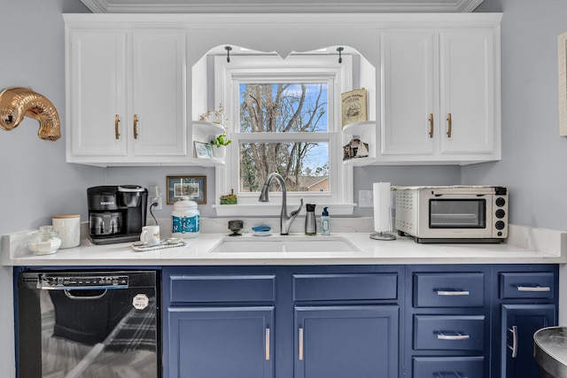 kitchen with dishwasher, blue cabinetry, white cabinets, and a sink