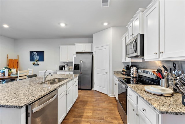 kitchen with sink, white cabinets, a center island with sink, and stainless steel appliances