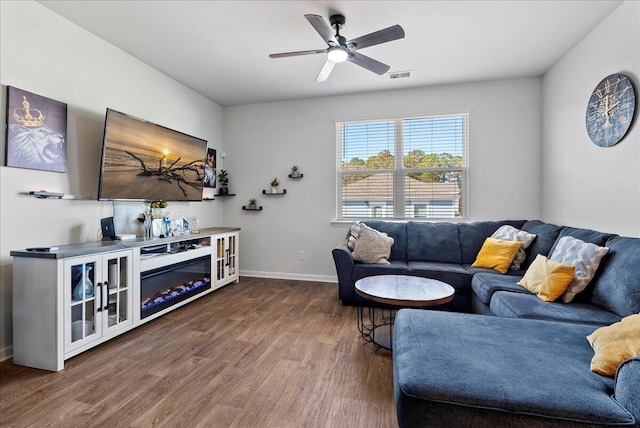 living room featuring dark wood-type flooring and ceiling fan