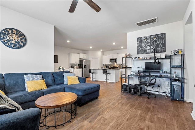 living room featuring ceiling fan and wood-type flooring