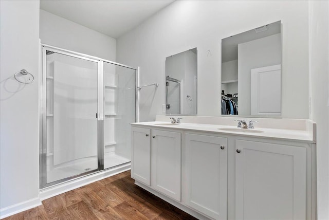 bathroom with hardwood / wood-style floors, walk in shower, and vanity