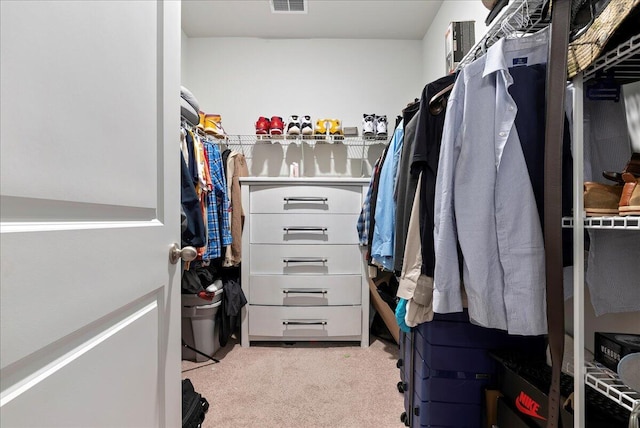 walk in closet featuring light carpet