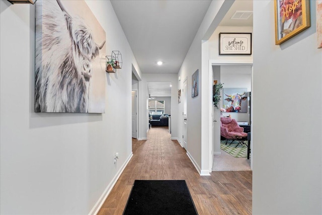 hallway with hardwood / wood-style flooring