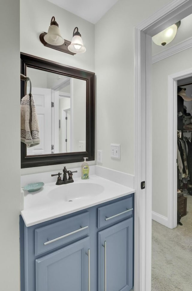 bathroom featuring baseboards, ornamental molding, and vanity