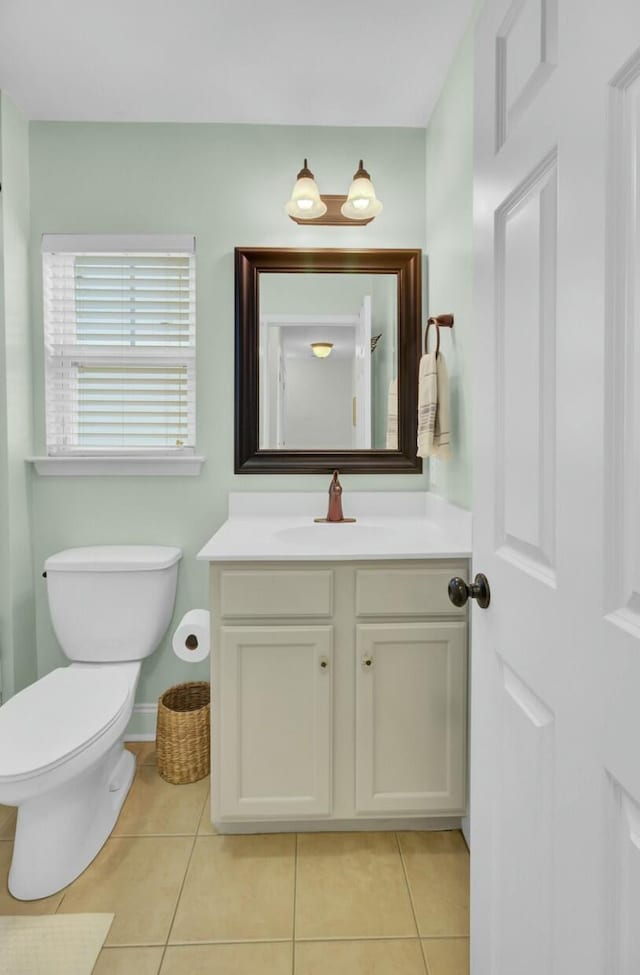 bathroom featuring tile patterned floors, baseboards, toilet, and vanity