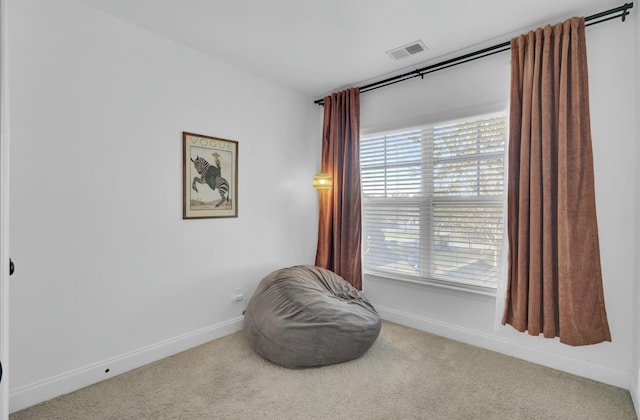 living area featuring visible vents, baseboards, and carpet