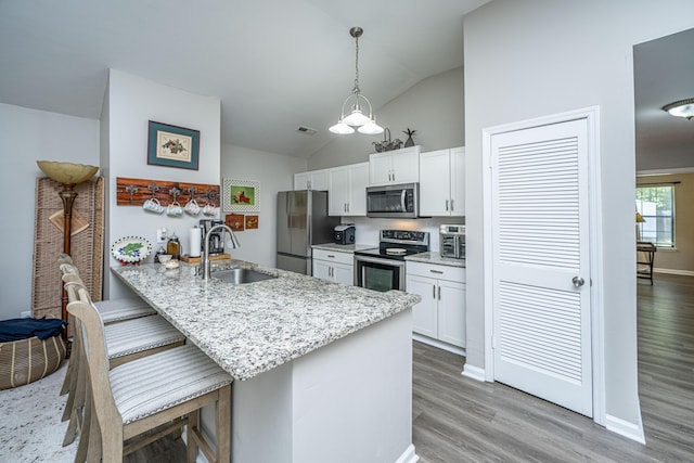717 Temple Rd Unit B, Ladson, SC 29456 - kitchen with appliances with stainless steel finishes, a sink, white cabinets, a breakfast bar area, and light stone countertops