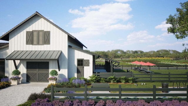 view of property exterior featuring a barn, fence, an outdoor structure, and board and batten siding