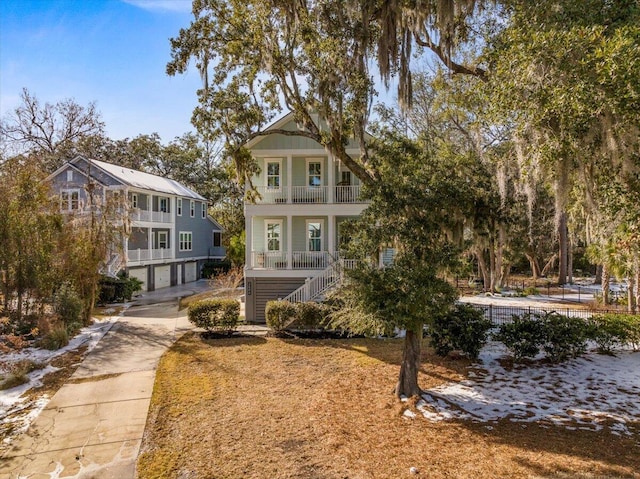 view of front facade with a garage, a balcony, and a porch