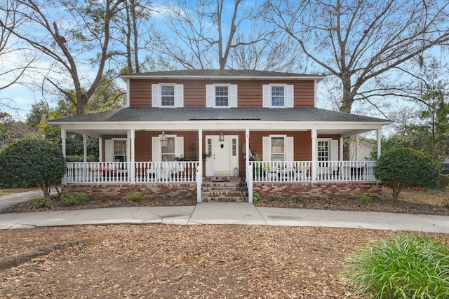 farmhouse featuring covered porch and a shingled roof