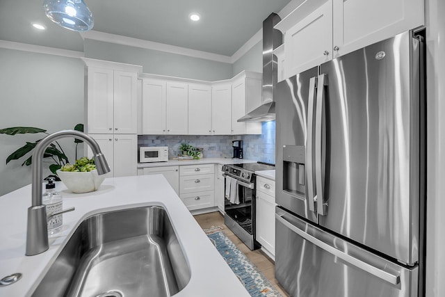 7416 Indigo Palms Way, Johns Island, SC 29455 - kitchen featuring stainless steel appliances, a sink, wall chimney exhaust hood, light countertops, and crown molding