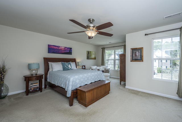 bedroom featuring multiple windows, ceiling fan, and light carpet