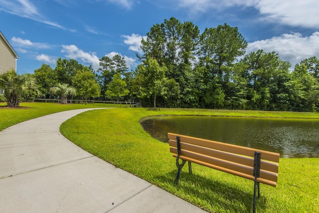 view of home's community with a lawn and a water view