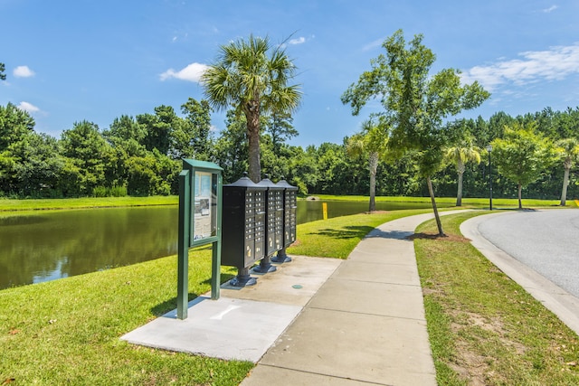 surrounding community featuring mail boxes, a yard, and a water view