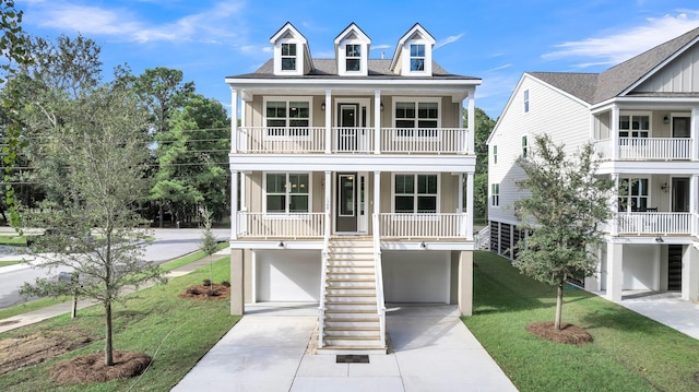 raised beach house featuring covered porch, a front yard, and a garage