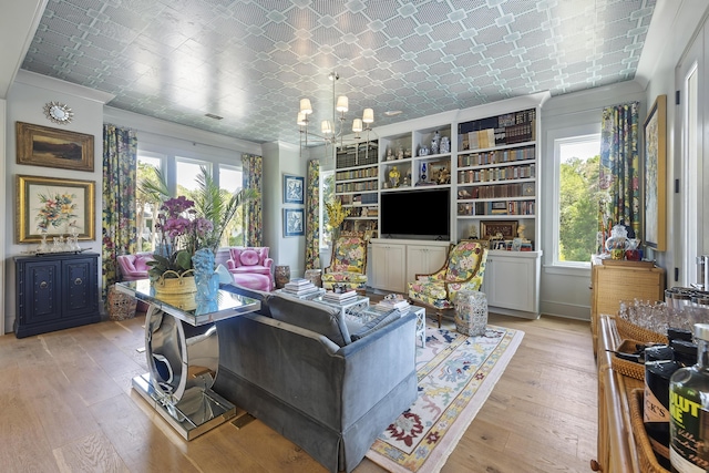 living room with crown molding, an inviting chandelier, an ornate ceiling, and light wood-style floors