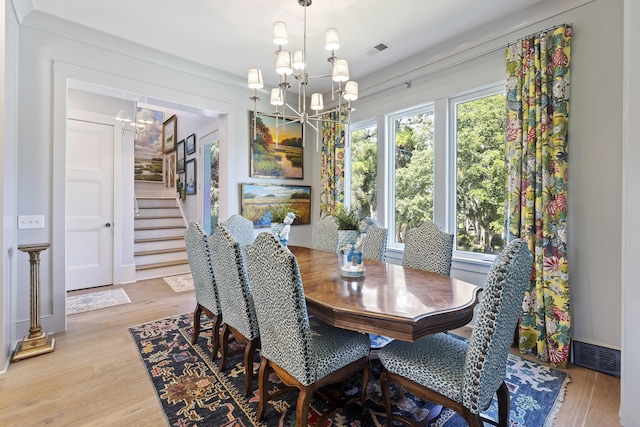 dining area with visible vents, a chandelier, stairway, and light wood-type flooring