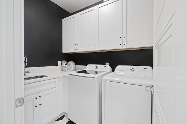 washroom featuring separate washer and dryer, a sink, and cabinet space
