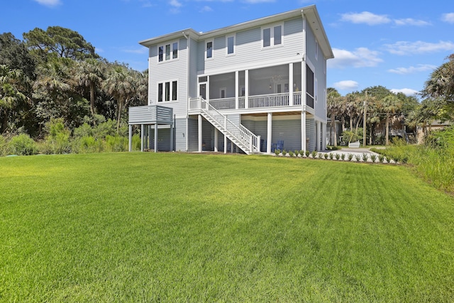 rear view of property with a lawn, stairs, and a sunroom