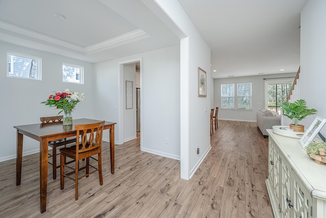 dining room with baseboards, a raised ceiling, stairway, light wood-type flooring, and recessed lighting